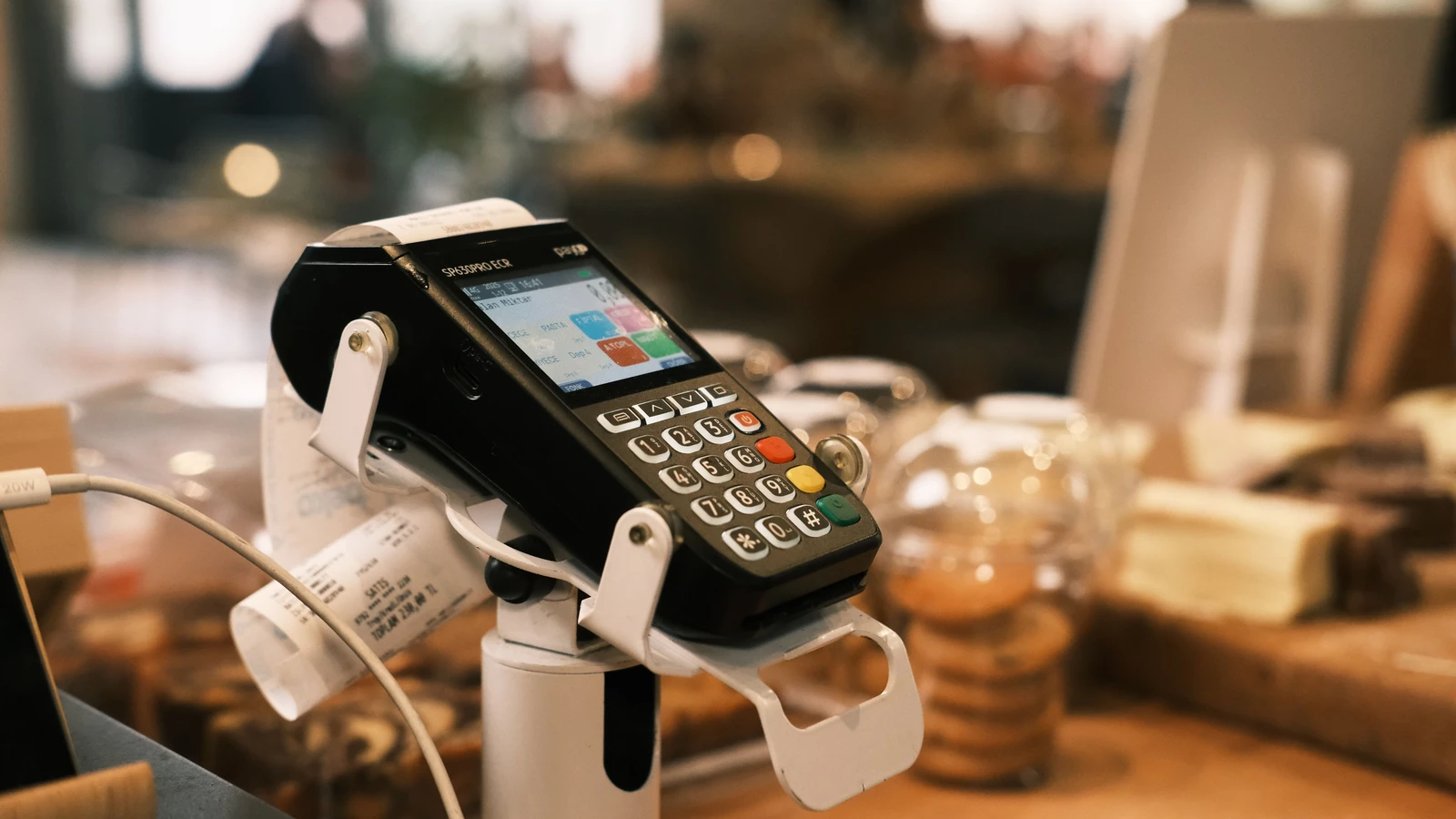 Betaalterminal met kassaticket op de toog van een koffiezaak