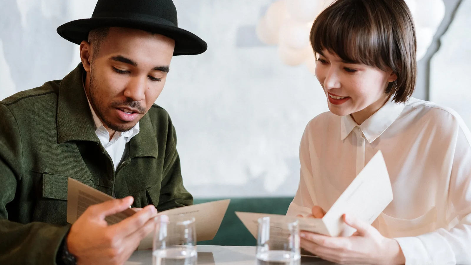 Twee gasten bekijken samen de menukaart aan een tafeltje in een restaurant